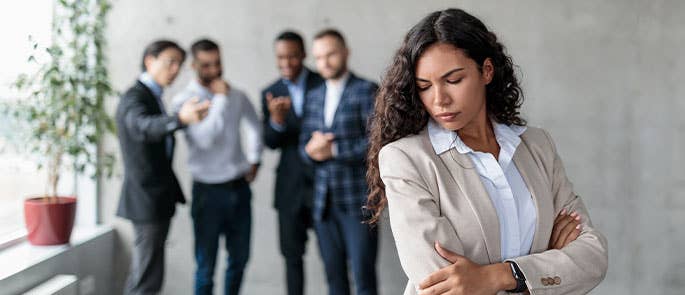 group of men peer pressuring a woman at work