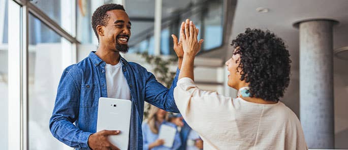 colleagues fostering a good work relationship and high-fiving