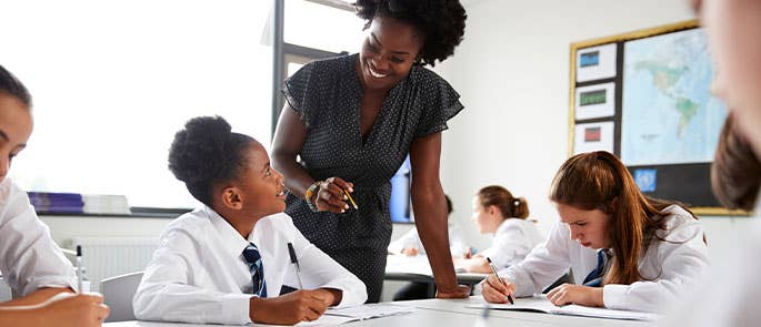 Teacher in a classroom smiling with students