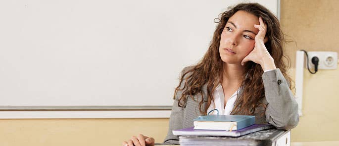 teacher stressed at desk in classroom
