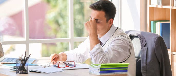 stressed teacher at desk in classroom
