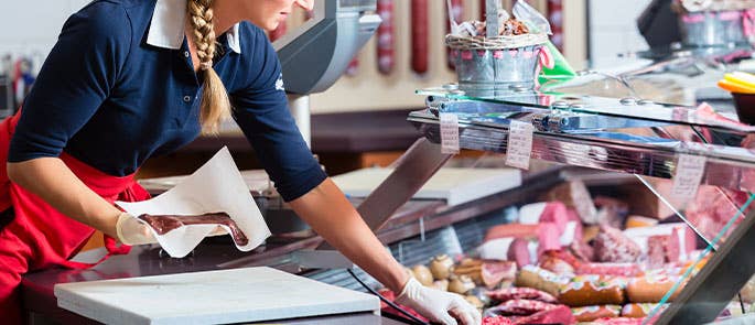 butcher taking meat out of display cabinets