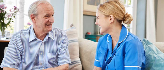 carer and a patient sat together smiling 