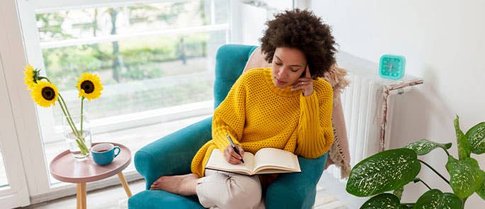 Woman writing in diary to help with negative thinking