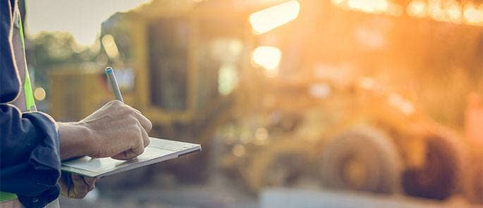 Construction worker checking regulations on site
