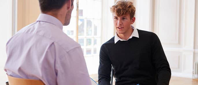 Disciplinary meeting between teacher and high school student in a school 