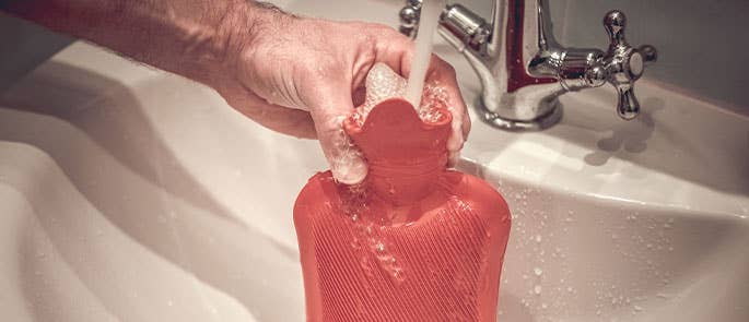 Hot water bottle being filled from the tap
