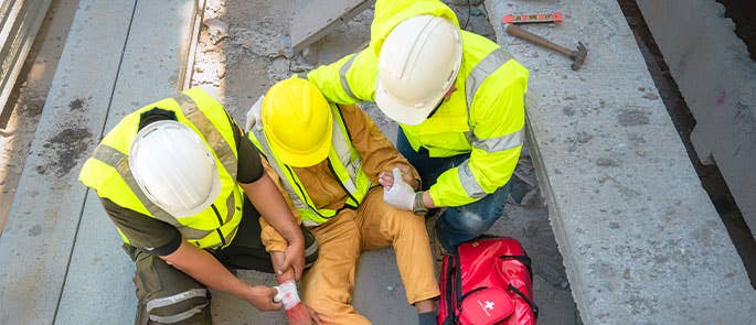Construction workers doing the secondary survey on coworker who has had an injury