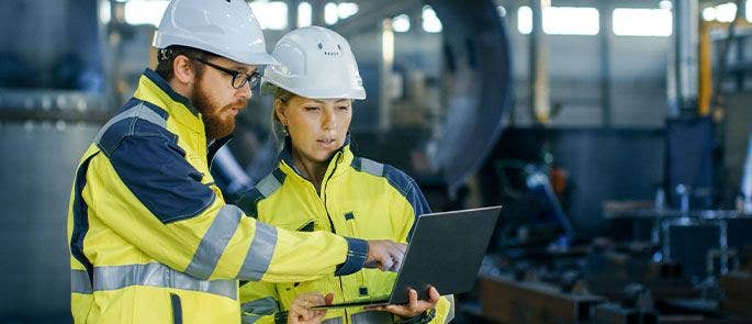 Managers on a construction site checking staff records
