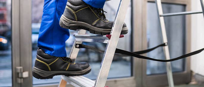 Man climbing a ladder at work