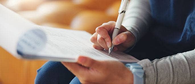 Member of staff reading through a handbook
