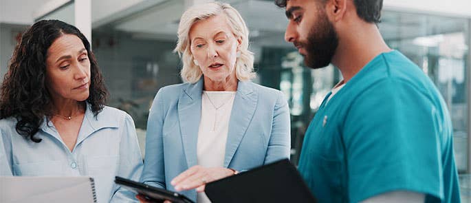 manager or inspectors talking to healthcare professional with notes