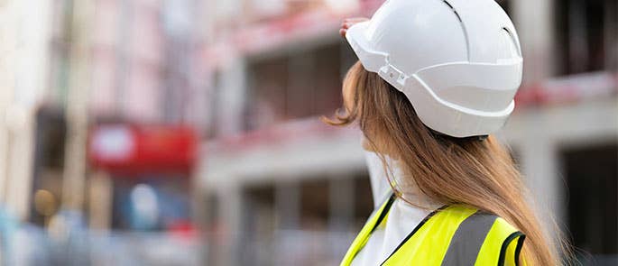 builder wearing hard hat and vest at work