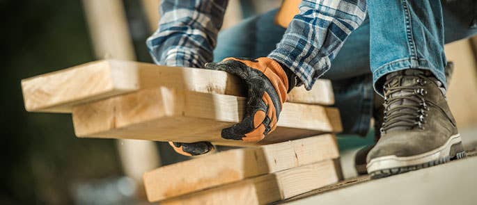 Builder moving planks of wood at work