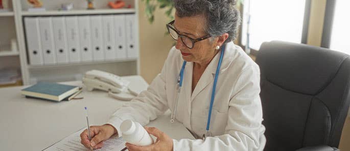 health and social care professional administering medication and writing notes about the administration