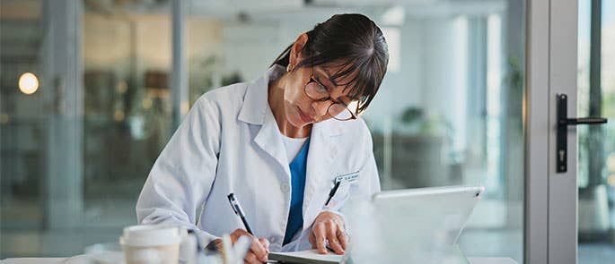 healthcare professional writing notes in records