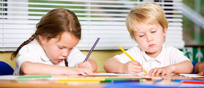 two kids colouring in at school