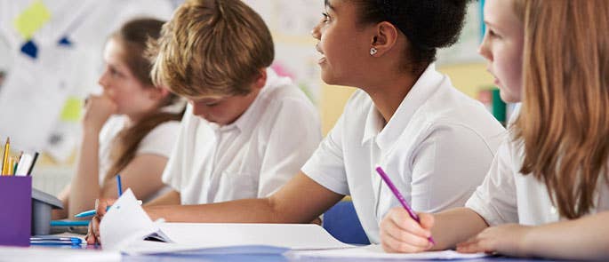 Children in classroom colouring in a worksheet