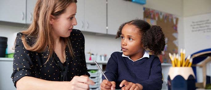 Child speaking to a teacher at school
