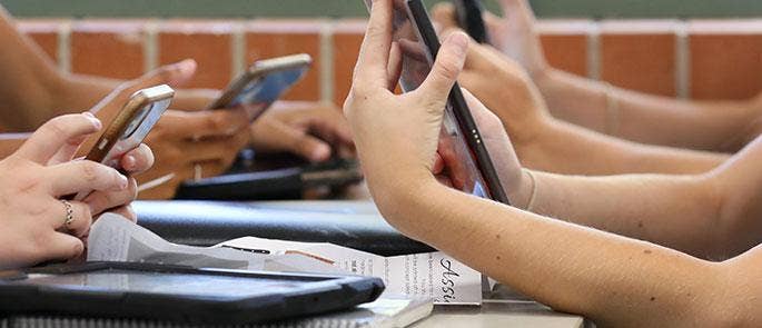 Pupils using phones at a table
