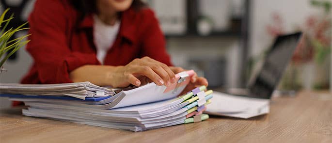 Employee looking through paper files and documents at work