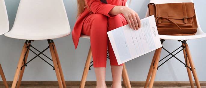 Woman waiting in office room with resume and job reference list