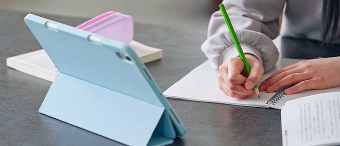 young person watching YouTube and making notes/doing schoolwork
