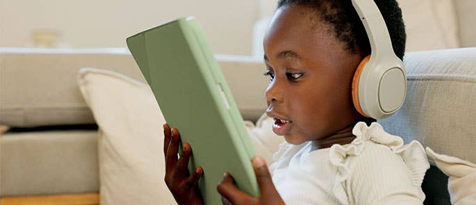 Child watching YouTube on iPad with headphones on 