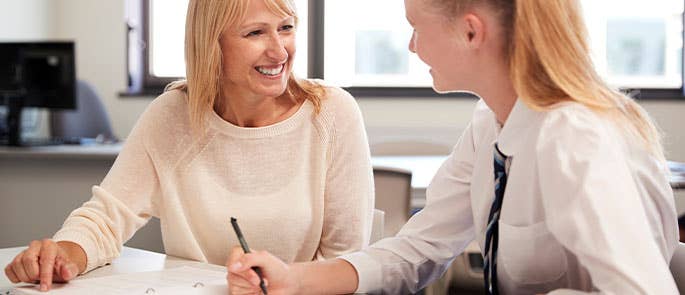student and teacher smiling together in classroom