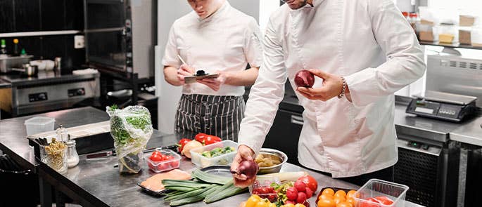 chefs in commercial kitchen with ingredients
