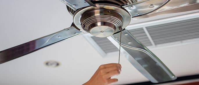 person turning on a ceiling fan