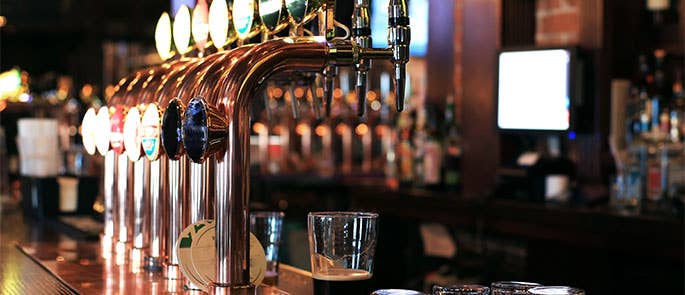 Bar taps on a bar with a pint underneath