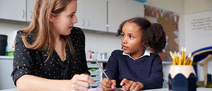 Teacher talking with a pupil in school