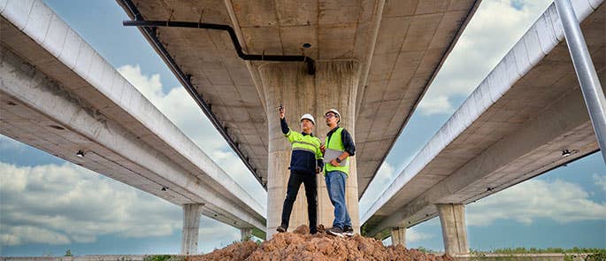 two civil engineers on site in full PPE