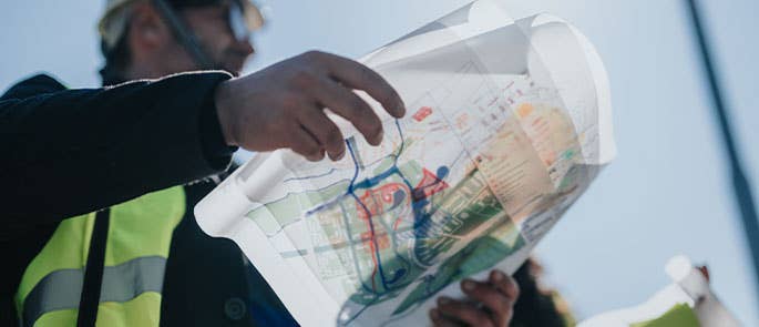 civil engineer at work with plans in hand