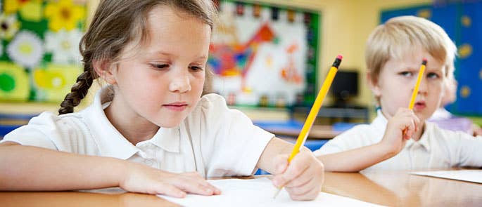 two children in a classroom, one struggling to focus on schoolwork