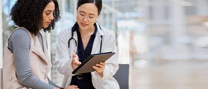 healthcare worker with patients talking through notes on tablet