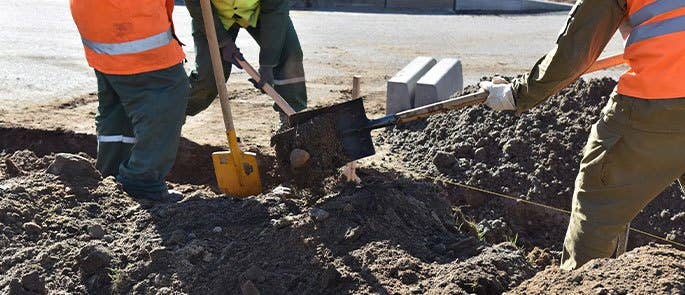 Construction workers digging on site