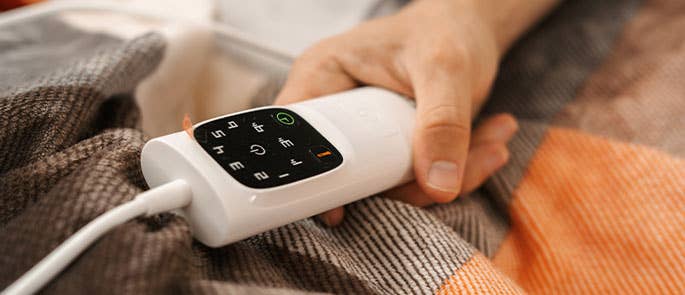 person using the dial on an electric blanket