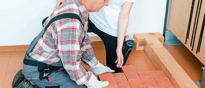 Occupational therapist helping patient with bricklaying work after back injury
