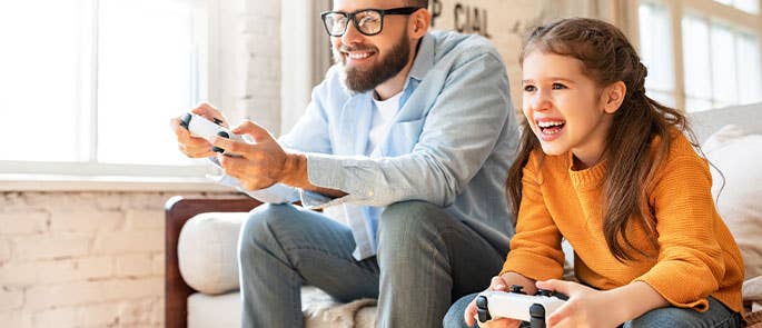 child playing console games with parent